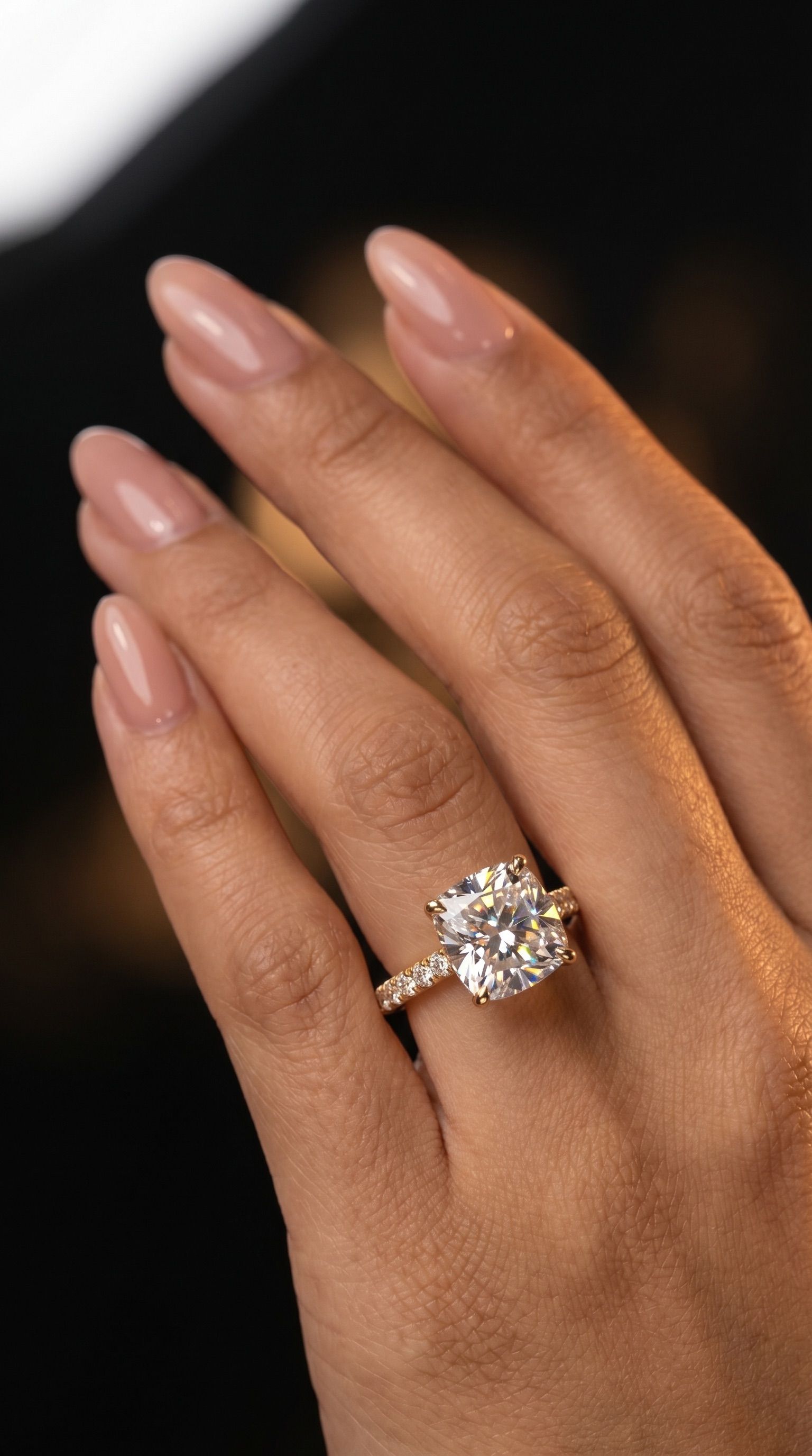 Cushion cathedral sidestone engagement ring worn on hand