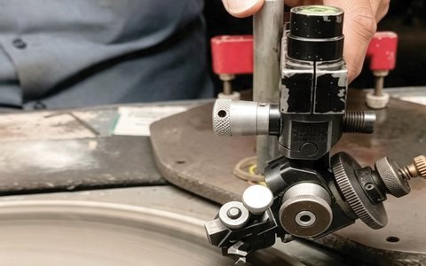 Diamond polishing equipment shaping facets on a rotating wheel.